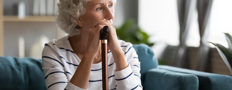 Femme avec une canne, pensive 