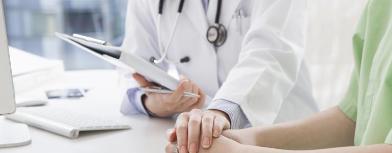 Médecin tenant la main d'un patient pour le réconforter 